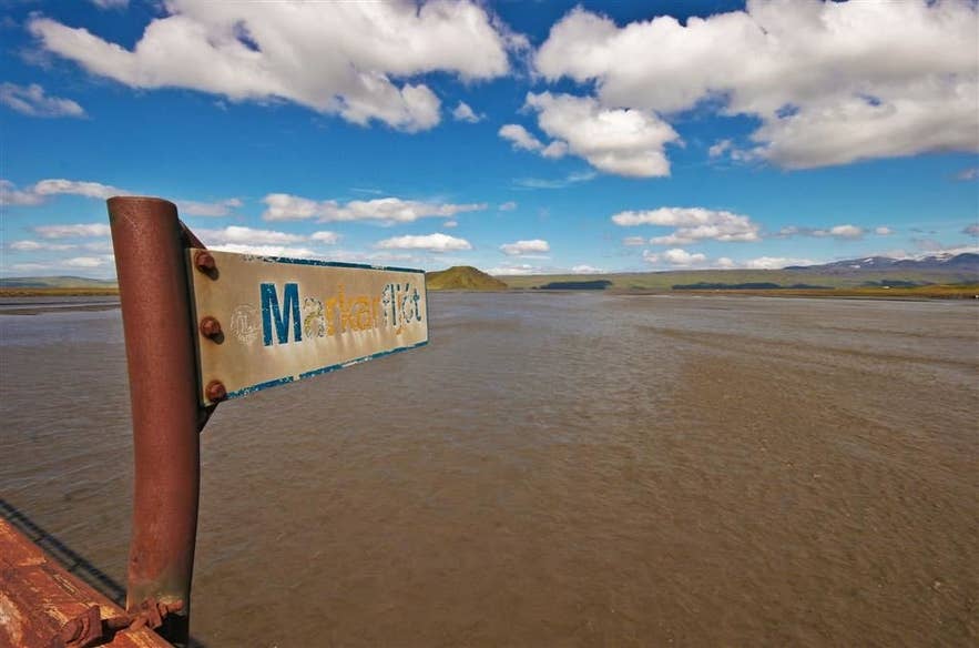 Markarfljót road sign beside the brown glacial river in summer Markarfljót road sign beside the brown glacial river in summer