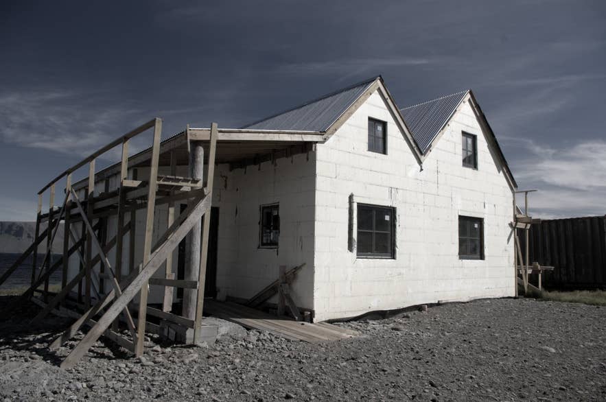 White house with scaffolding beside road 619 on the shore of Arnarfjörður in Selárdalur, Ketildalir