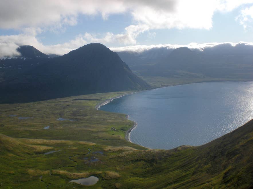Hlöðuvík bay, Hornstrandir, with its black beach, lagoon and green flats seen from the slopes above Hlöðuvík bay, Hornstrandir, with its black beach, lagoon and green flats seen from the slopes above