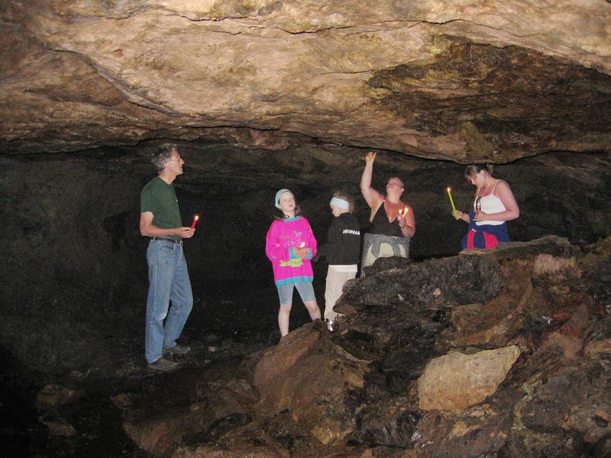 Visitors standing inside Gilsnáma lignite mine near Bolungarvík