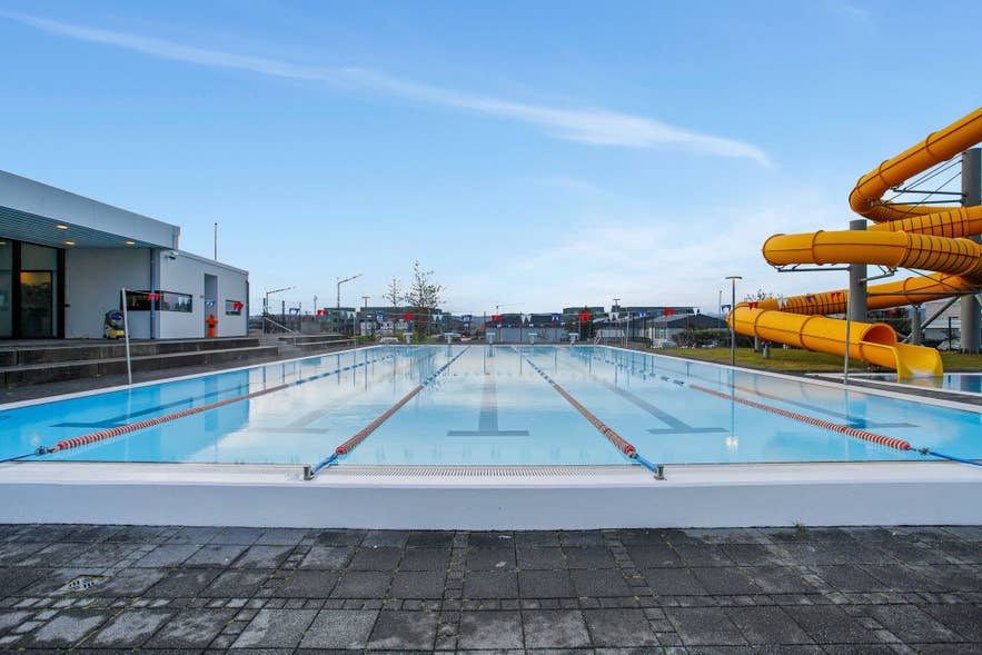 The outdoor lane pool and orange water slides at Alftaneslaug in Gardabaer.