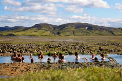 A group of adventurers taking a relaxing dip in a natural pool.