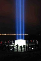 A group bonds at the Imagine Peace Tower over the message of Yoko Ono and John Lennon.