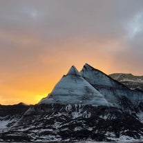 Solen går ner över några snötäckta toppar på Myrdalsjokull-glaciären.