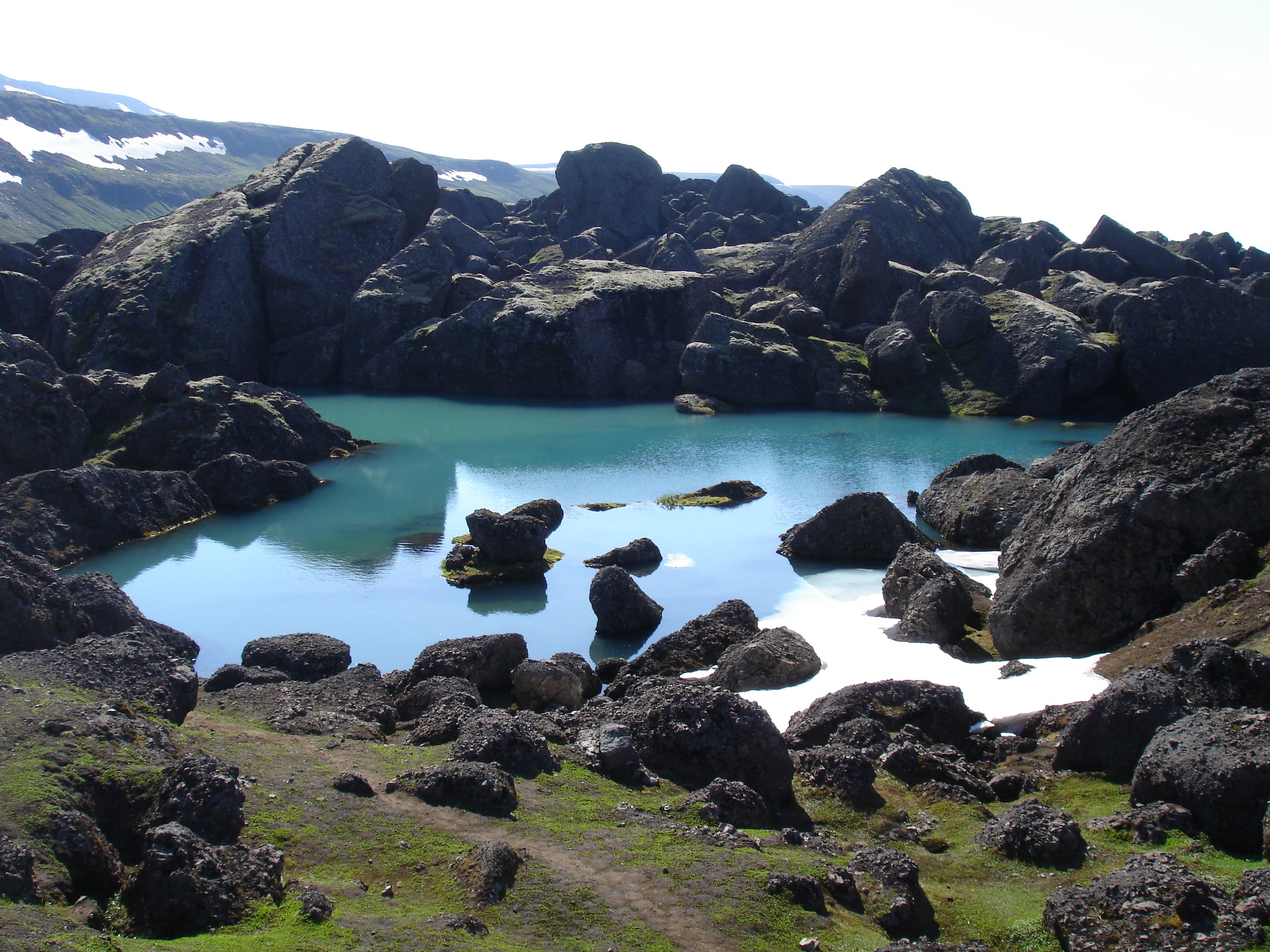 Un lac à Storurd entouré de blocs de roche noire