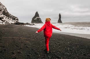 A traveler exploring the black sands of Reynisfjara on South Coast.