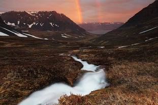 Un arcobaleno gemello si inarca su un fiordo, in un giorno di sole e splendore dell'estate islandese.