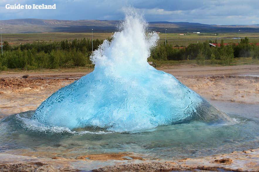 Il geyser Strokkur erutta con acqua blu brillante nel Circolo d’Oro islandese, una famosa attrazione geotermica vicino a Thingvellir.