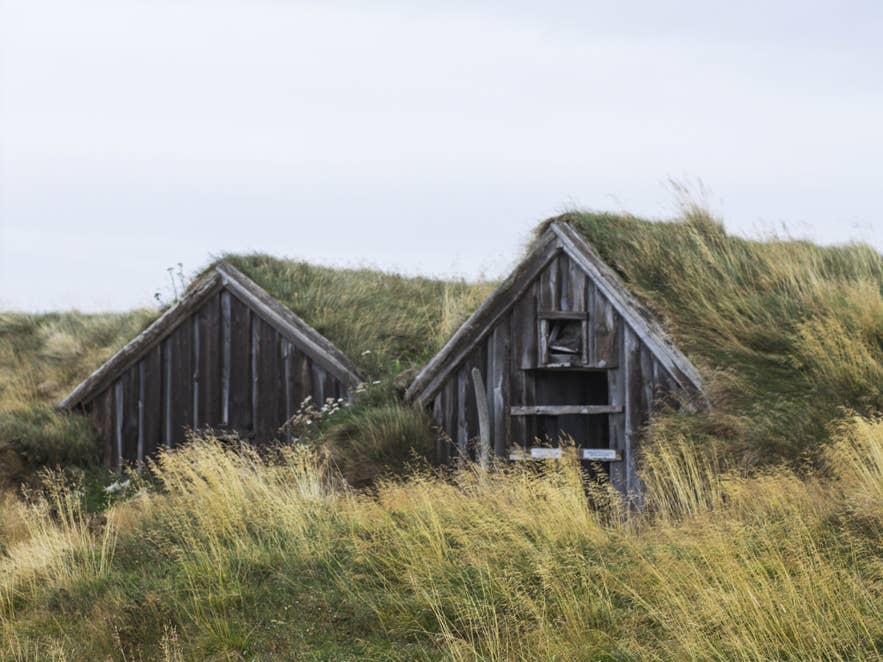 Traditional Icelandic turf houses in a grassy landscape tied to the history of galdur and Icelandic witchcraft.