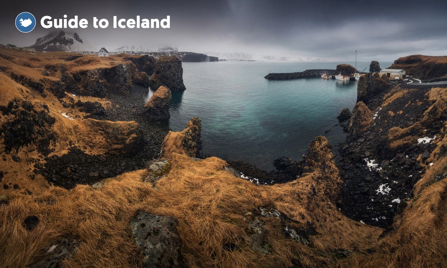 The Arnastapi harbor is picturesque and features striking coastal cliffs nearby.