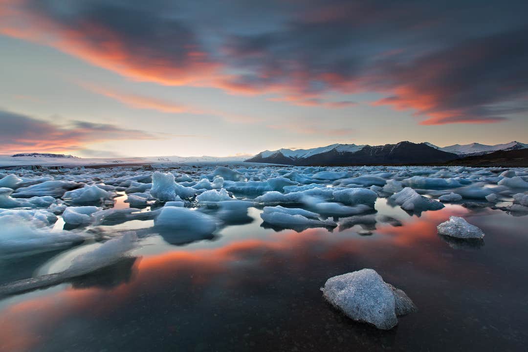 Il cielo estivo al tramonto si riflette perfettamente sulla perla della costa sud islandese, la laguna glaciale Jokulsarlon.