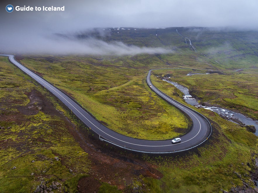 A road arches through the Eastfjords towards Seydisfjordur.