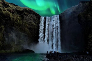 The aurora borealis illuminates the beautiful Skogafoss waterfall in Iceland.