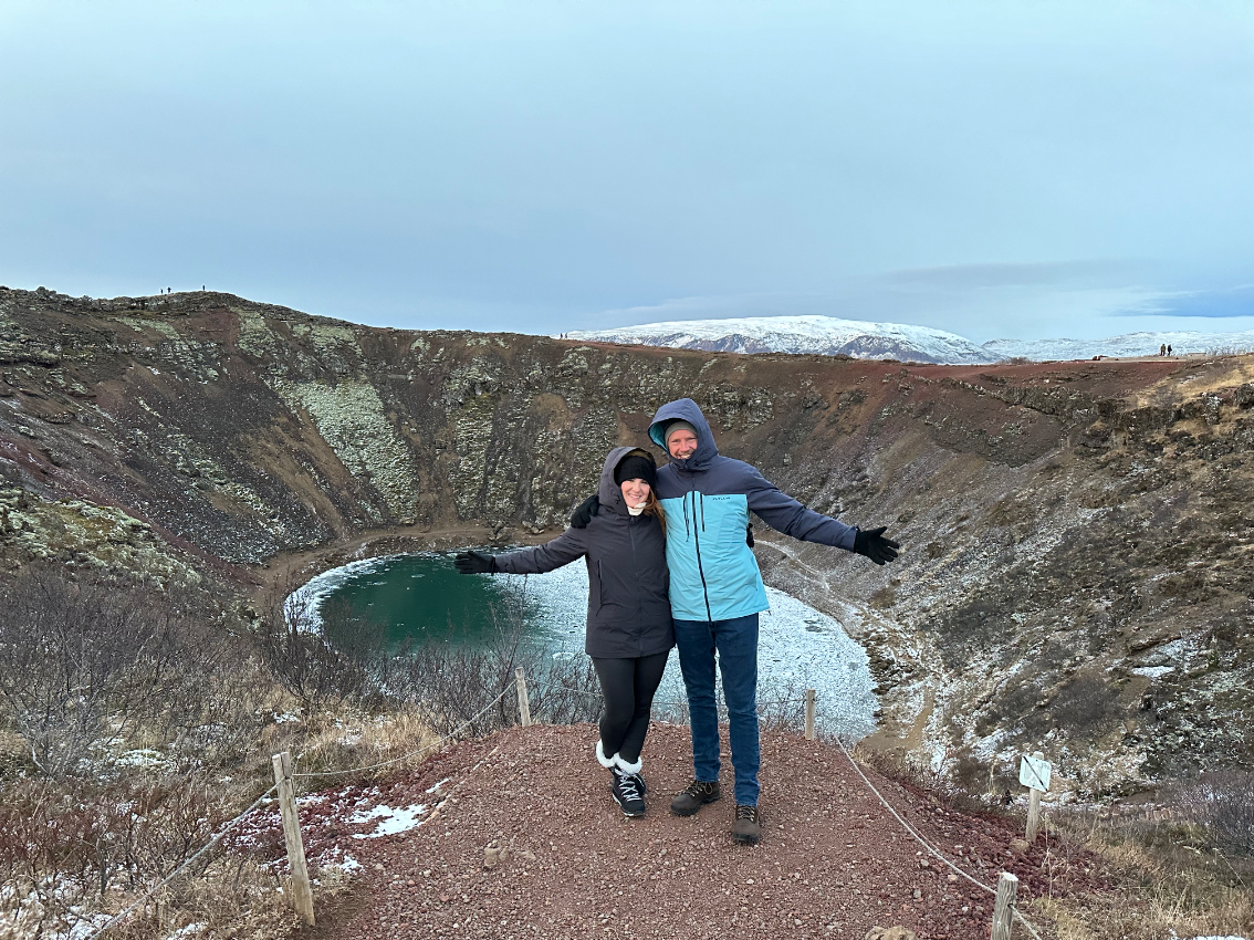 Two travelers posing in front of Kerid crater in Iceland.