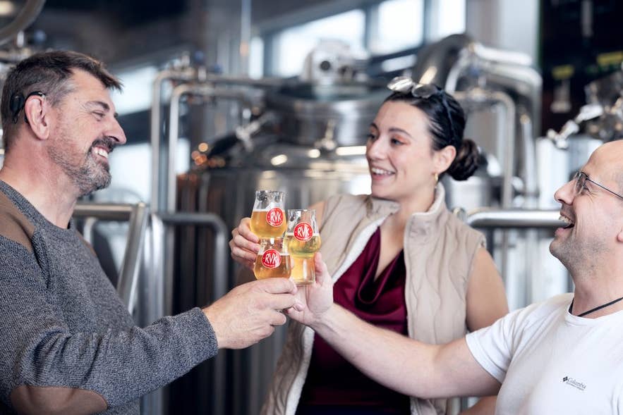 People toasting small glasses of craft beer inside a Reykjavik microbrewery