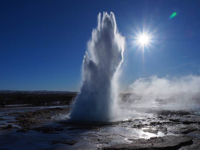 Strokkur geyser shoots hot water into the air.