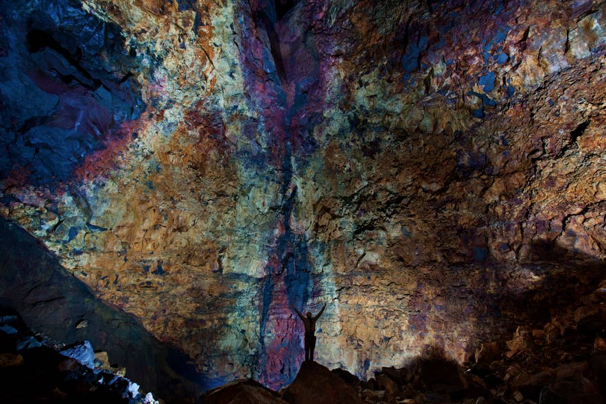 A visitor dwarfed by the multicolored walls of the Thrihnukagigur magma chamber