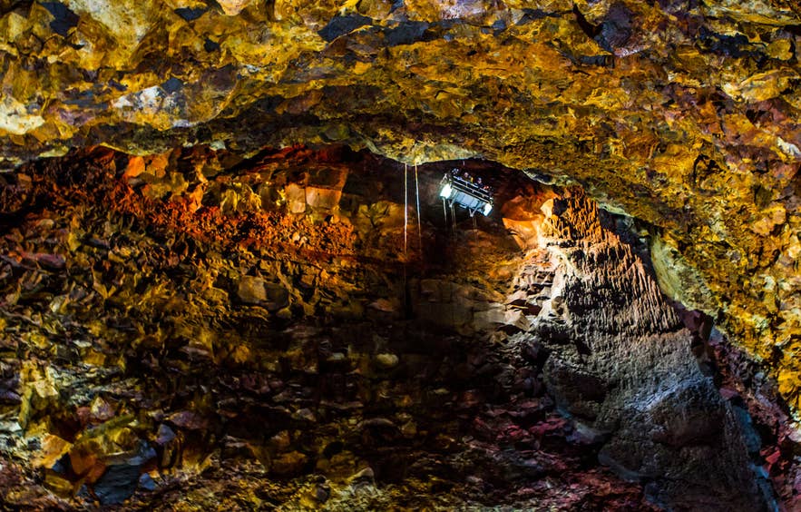 Red and copper rock walls and the cable lift inside Thrihnukagigur magma chamber