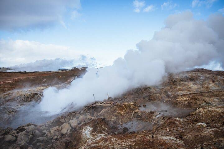 雷克雅内斯半岛上，厚重地热蒸汽覆盖着古纳威尔热泉崎岖的火山地貌。
