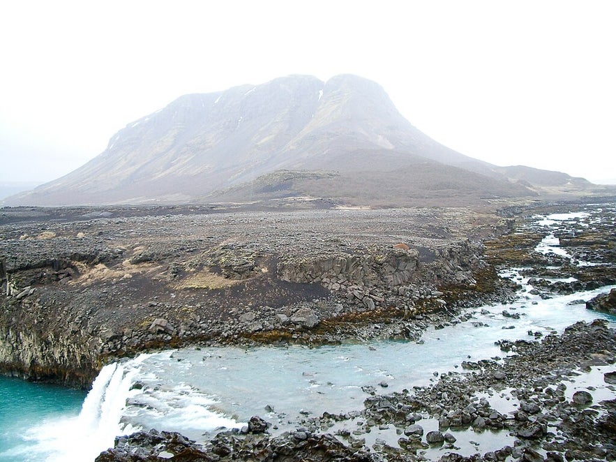 A side-on view of the Thjofafoss waterfall with Mount Burfell behind it.