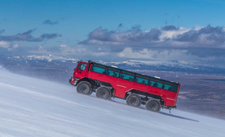 Un grande monster truck rosso sale sul ghiacciaio Langjokull.