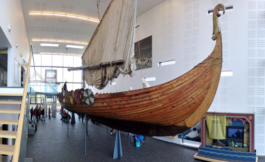 Viking longship replica on indoor display at the Viking World Museum in Keflavík, Iceland, showcasing traditional wooden craftsmanship and Norse sailing history.