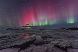 Nordlyset fylder himlen og farver omgivelserne i deres farver, især over gletsjerlagunen Jokulsarlon.