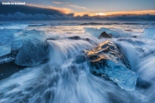 Góry lodowe z laguny lodowcowej Jökulsárlón są obmywane i polerowane przez fale u wybrzeży Diamentowej Plaży.