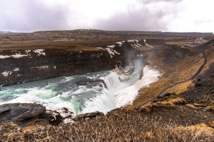 Gullfoss waterfall cascading powerfully through a rugged canyon in the Icelandic wilderness.