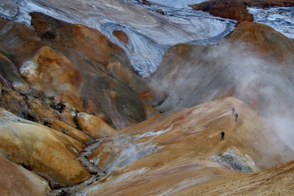 People walk amid the otherworldly landscapes of the Kerlingarfjoll mountain range during a helicopter tour landing.