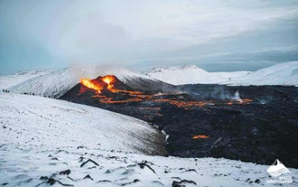 A newly-erupted volcano looks captivating with it's bright orange lava contrasting beautifully against a snow-covered landscape on the Reykjanes peninsula.