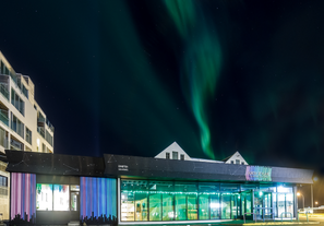 Nordlyset kaster en strålende stribe af farver over nattehimlen over Aurora Reykjavik - The Northern Lights Center.