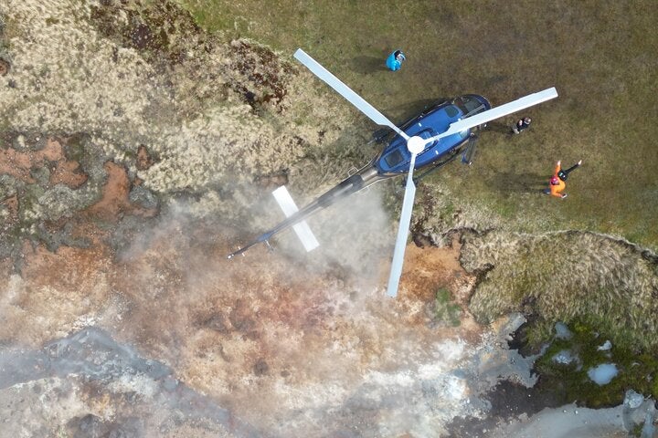 A helicopter surrounded by Hengill area's steam.