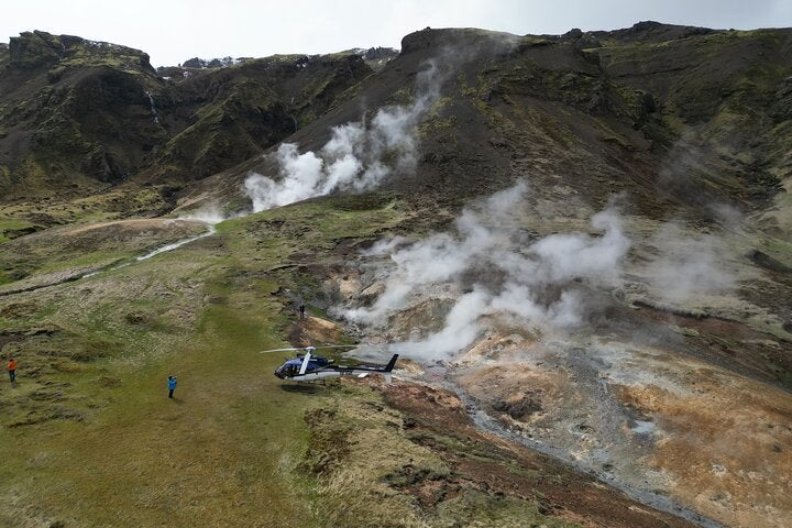 A helicopter lands in the Hengill geothermal area.