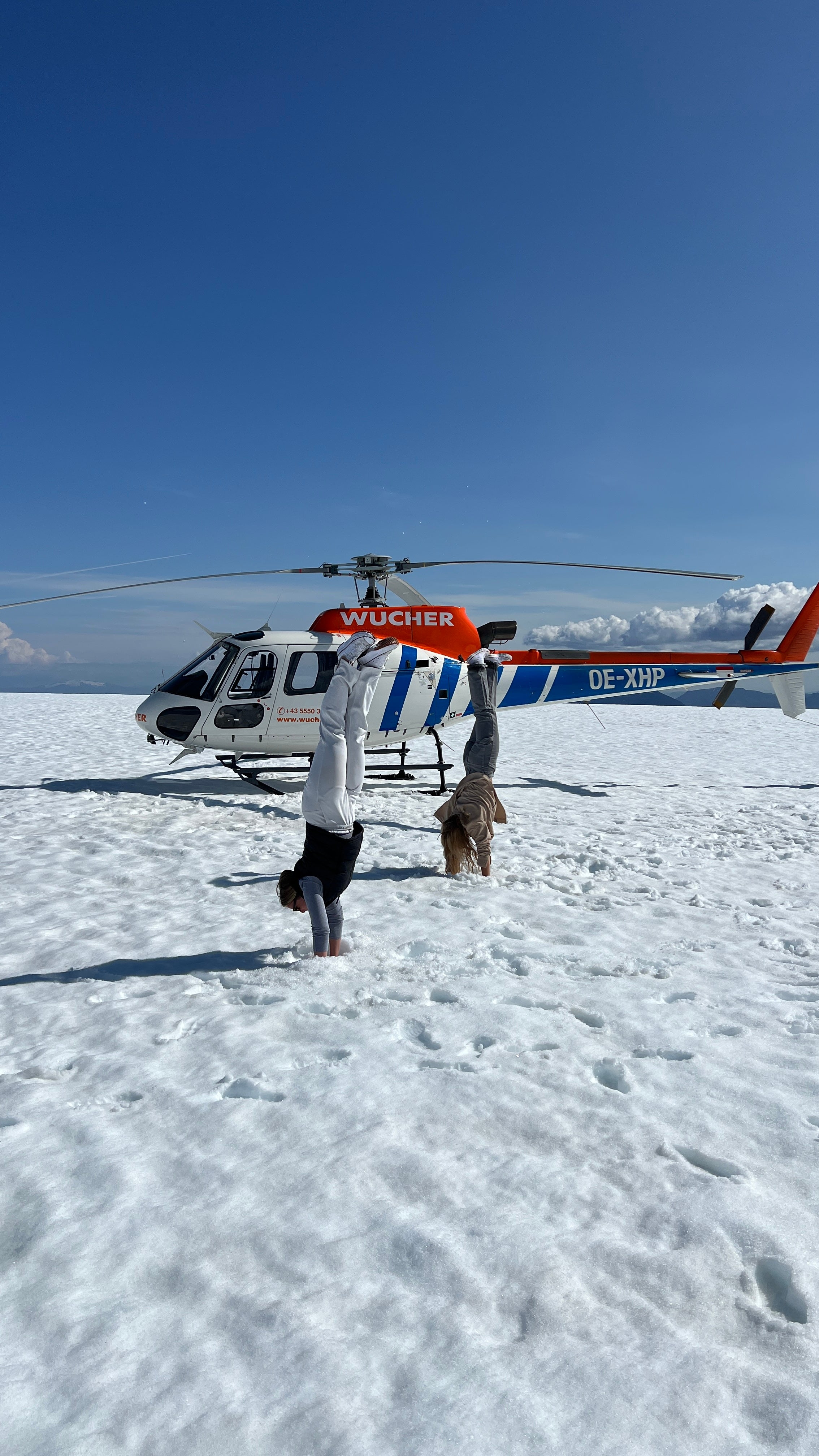 A helicopter and people in front of it on a glacier in Iceland.