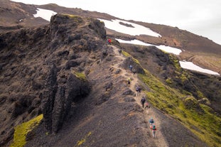 Hikers crossing a mountain ridge in the Icelandic Highlands.