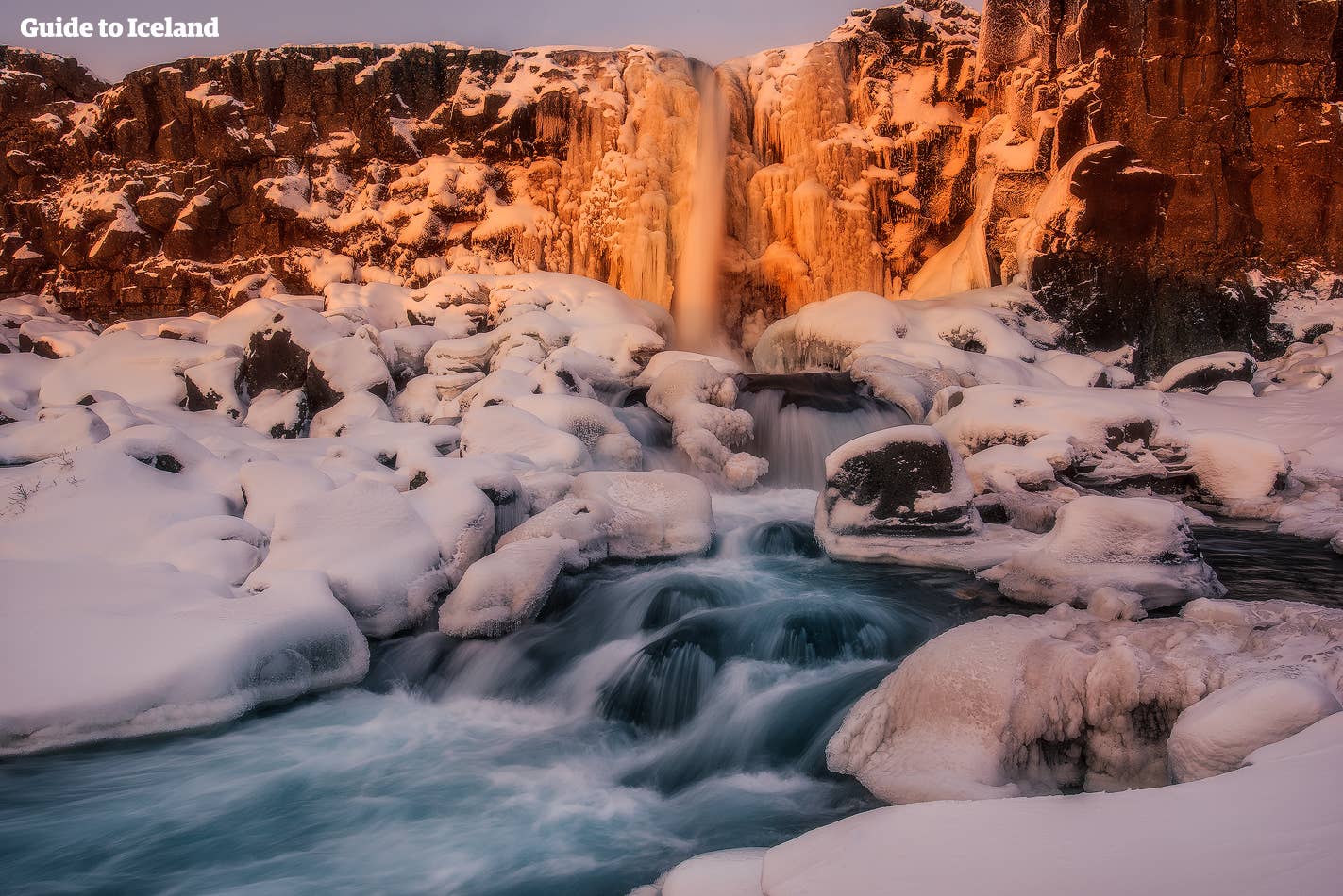 Winterse gloed boven de Öxarárfoss-waterval in Nationaal park Þingvellir