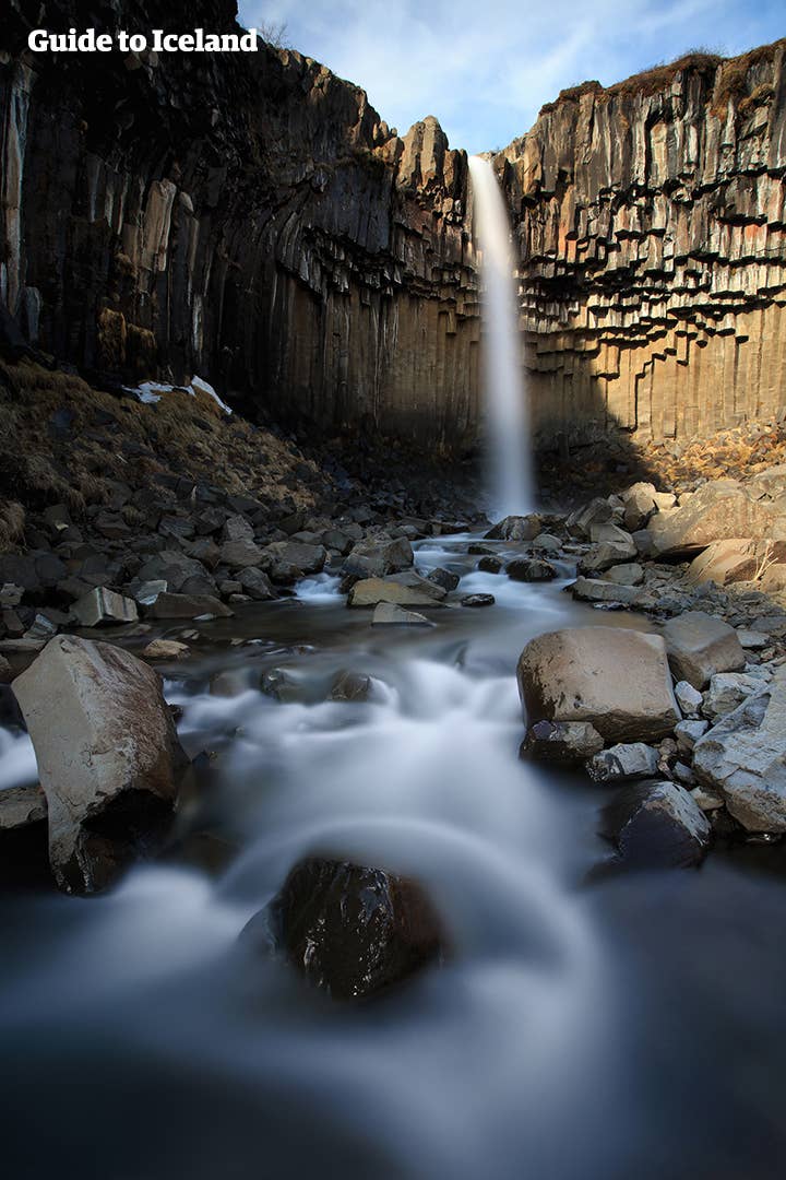 Zwarte zuilen omringen de Svartifoss-waterval in het natuurreservaat Skaftafell, Zuidoost-IJsland