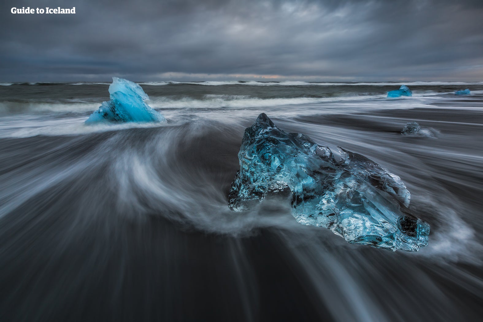 Dramatic sky over a black, iceberg-filled beach
