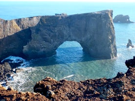 The massive rock arch at Dyrhólaey peninsula on the South Coast bathed in the summer sun's rays.