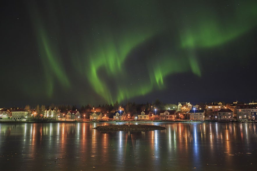 L'aurora sopra lo stagno a Reykjavik, Islanda.