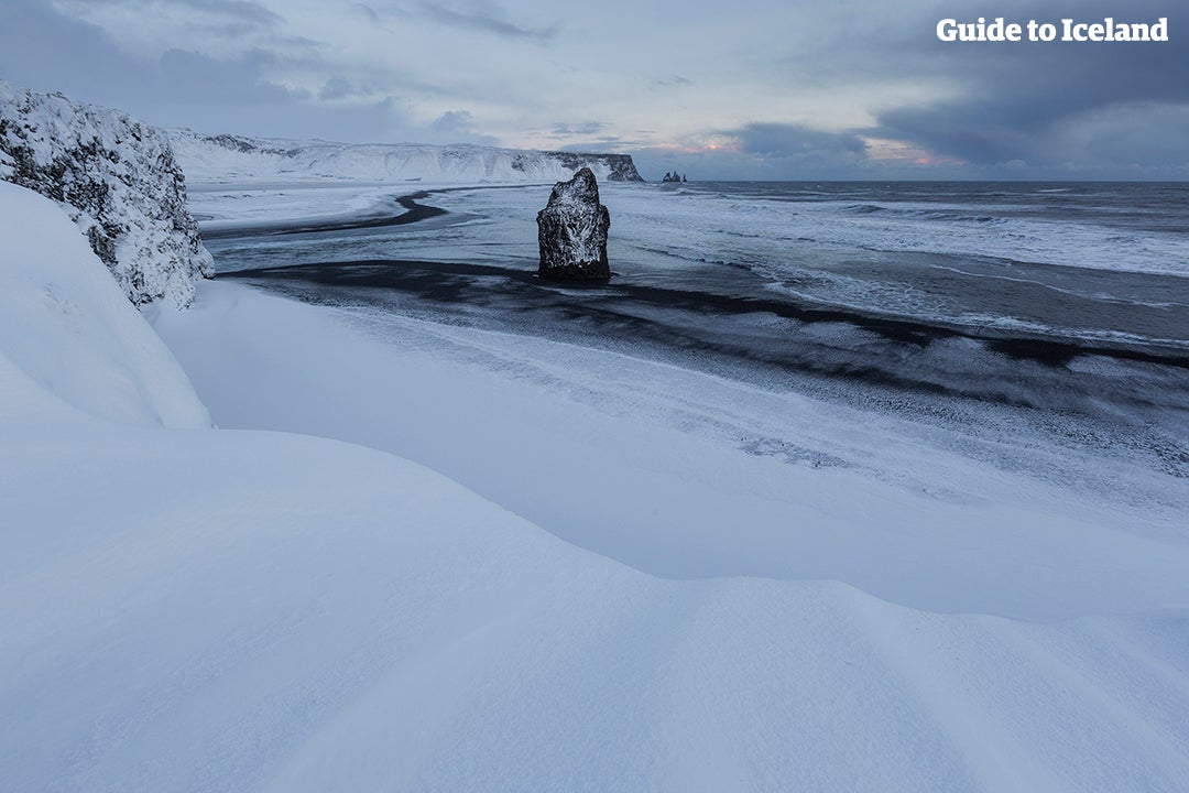 Reynisfjara beach covered by a soft, white winter blanket.