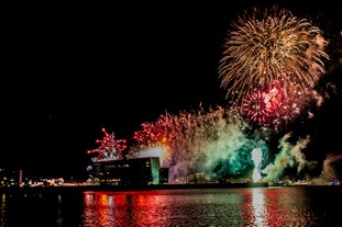 Das Feuerwerk zu Silvester wirft sein Licht auf die Konzerthalle Harpa in Reykjavík.