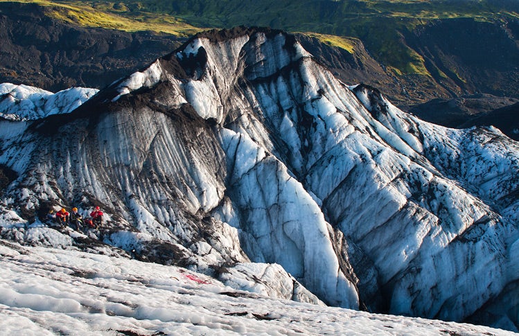Группа туристов с кошкими пересекает ледник Сольхеймайёкюдль в Исландии.
