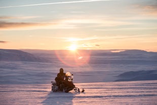 Súbete a una moto de nieve y comienza tu viaje a través del glaciar.