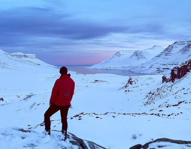 En reisende nyter det snødekte landskapet i Seydisfjordur og på Øst-Island.