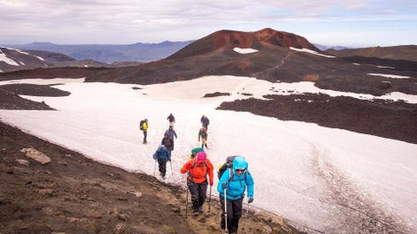 Hikers crossing a snowy path in the Highlands of Iceland.