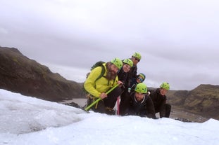 Adventurers posing for a photo above South Coast's Solheimajokull glacier.