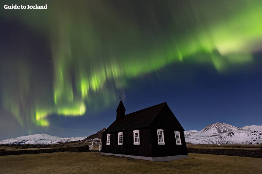 Aurores boréales au-dessus de l’église noire de Budir sur la péninsule de Snaefellsnes, Islande, un lieu de séjour époustouflant.