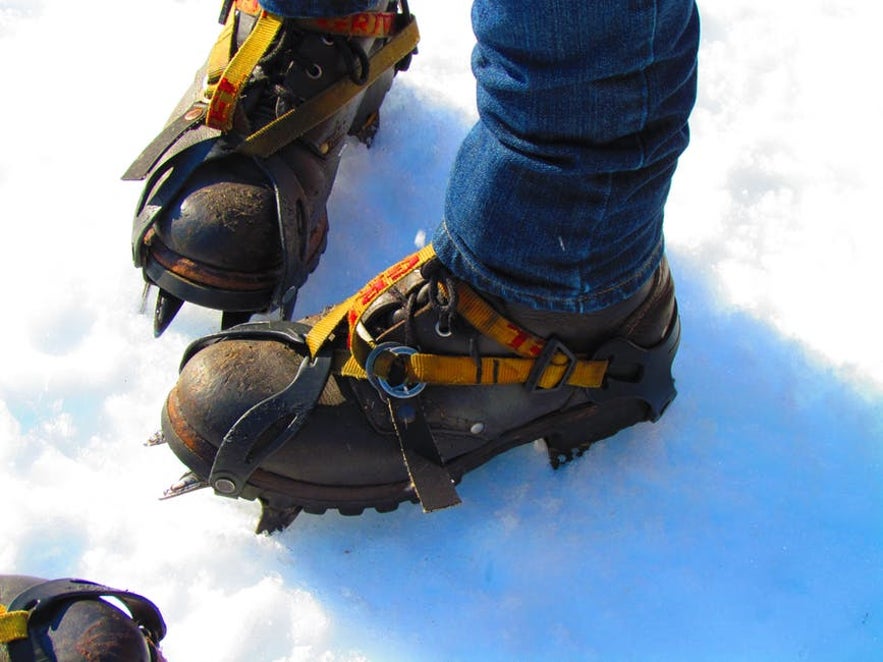 Pour une randonnée sur glacier en Islande, les crampons sont fixés sur la chaussure